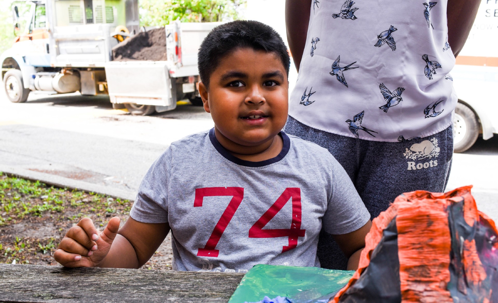 young boy standing and smiling in front of a volcano science experiment