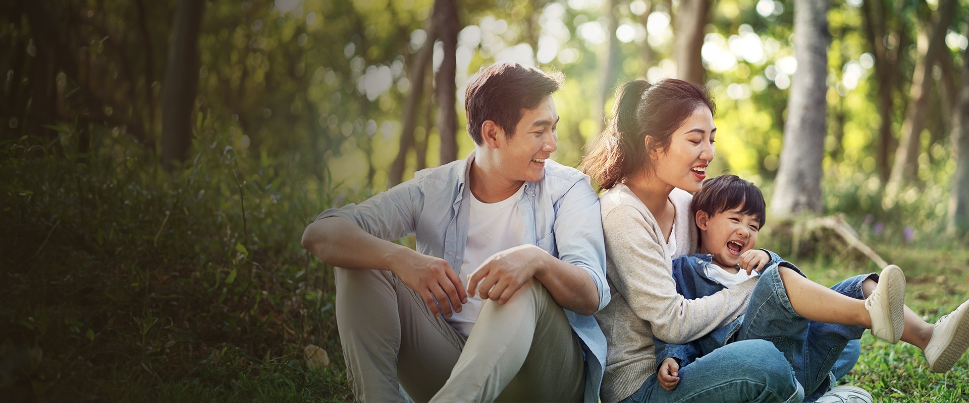 East Asian family consisting of a mother and father playing with child