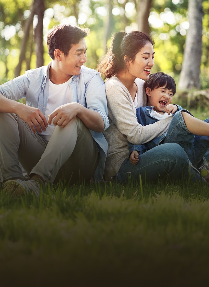 East Asian family consisting of a mother and father playing with child